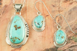 Genuine Pilot Mountain Turquoise set in Sterling Silver. Stunning Pendant and Earrings Set. 18 inch Sterling Silver Chain is included. Created by Navajo Artists John Nelson and Kathy Yazzie. The Pilot Mountain mine is located in Esmeralda County, Nevada.